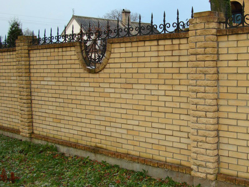 Забор из желтого кирпича с коваными пиками