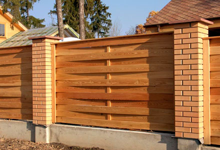 Деревянный забор для частного дома на кирпичных столбах