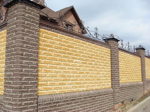 Забор из желтого кирпича с серыми кирпичными столбами